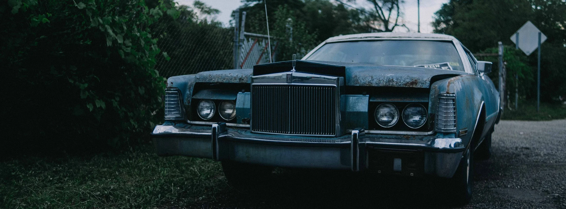 A 1970s coupe parked on gravel at dusk, graded with GX-01 American Sugar